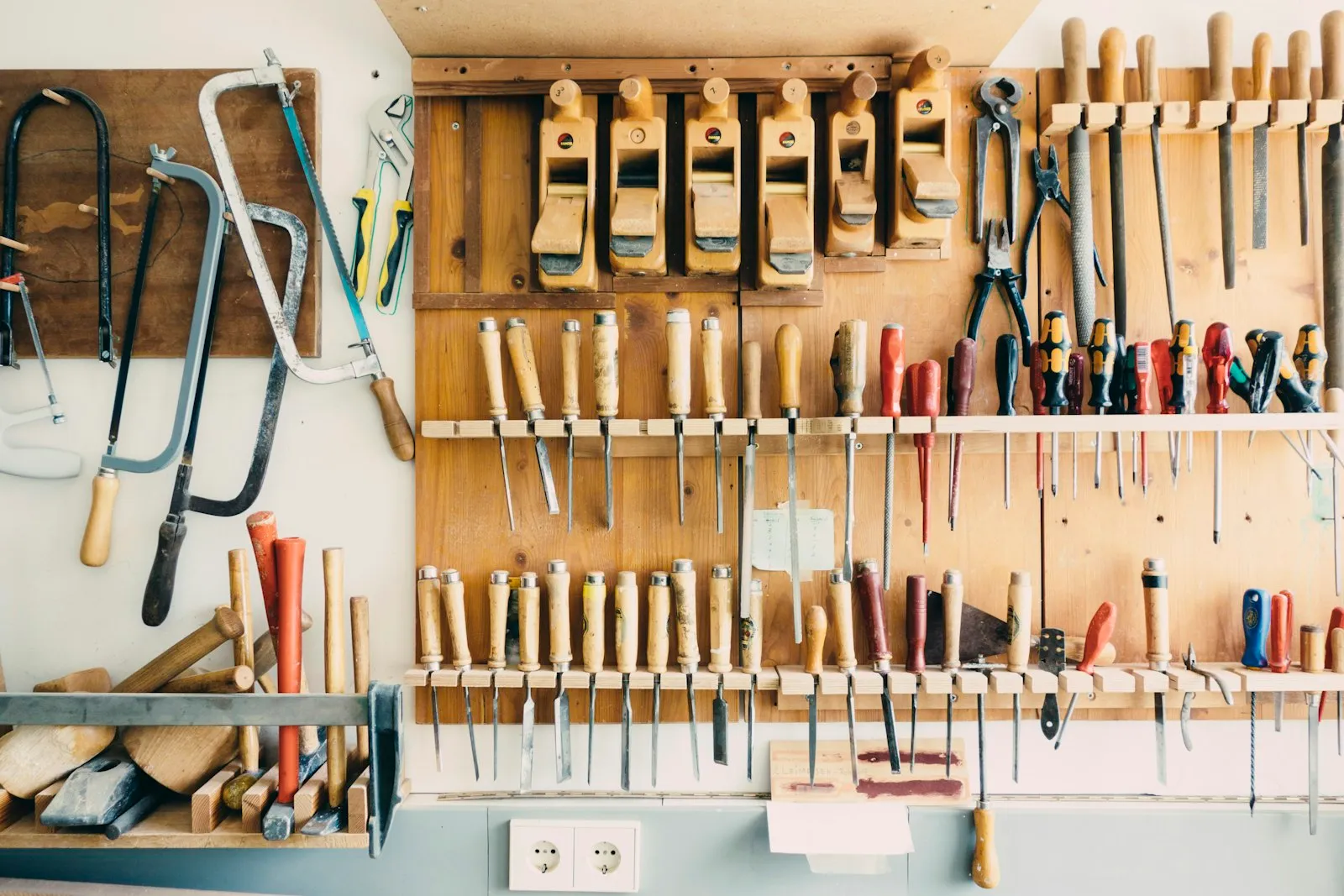 The tool wall at Hartley Joinery — hand planes, chisels and saws on a pegboard