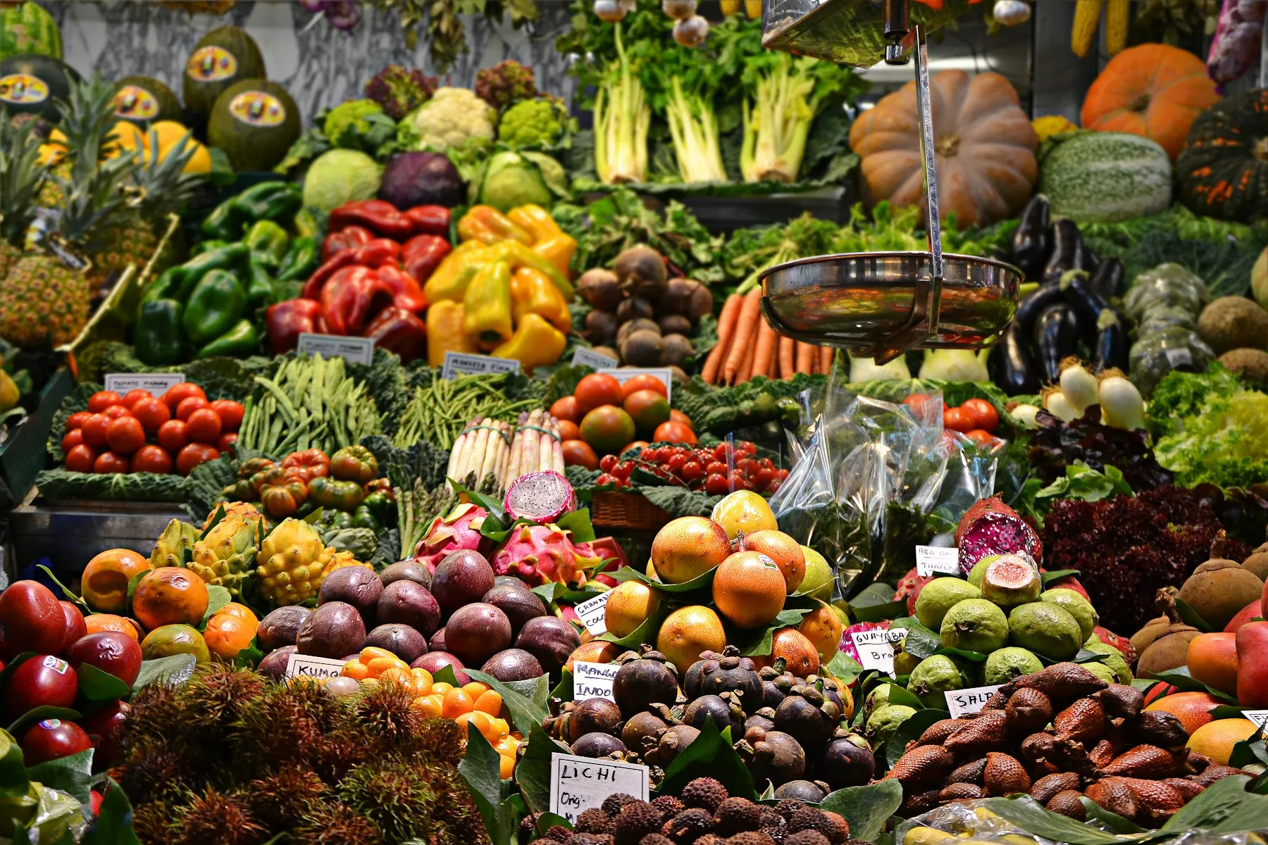 A market counter piled high with fresh fruit and vegetables
